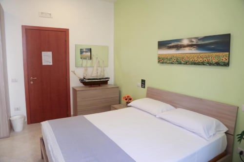 Camera doppia Girasole presso The Flower Garden B&B a Castellammare di Stabia con pareti verdi, letto, mobili in legno e
