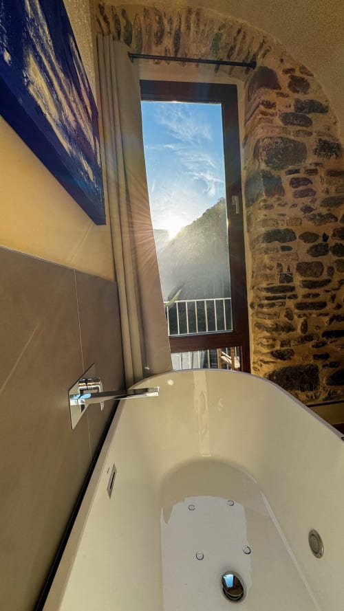 Luxurious bathtub with mountain view from Nervia room at Talking Stones hotel in Dolceacqua, Italy