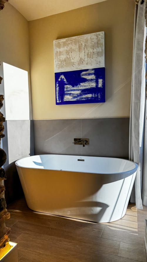 Modern freestanding bathtub in Nervia room at Talking Stones Group, Dolceacqua with artistic blue wall panel