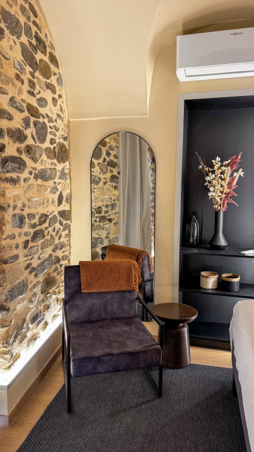 Nervia room at Talking Stones Group in Dolceacqua featuring stone walls, arched mirror, and modern furnishings