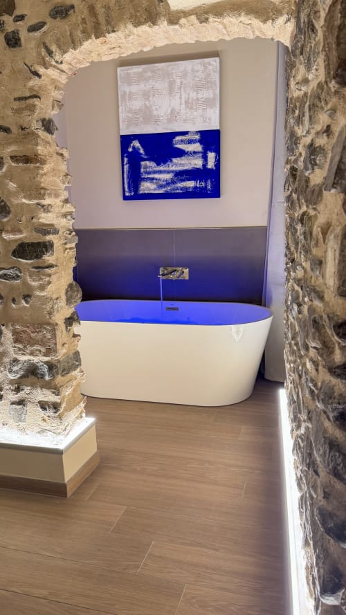 Modern white bathtub with blue interior in stone alcove at Talking Stones hotel, Dolceacqua