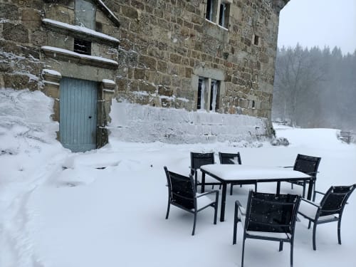 Zone de restauration extérieure enneigée avec chaises noires au Domaine De Maleval à Mars, France