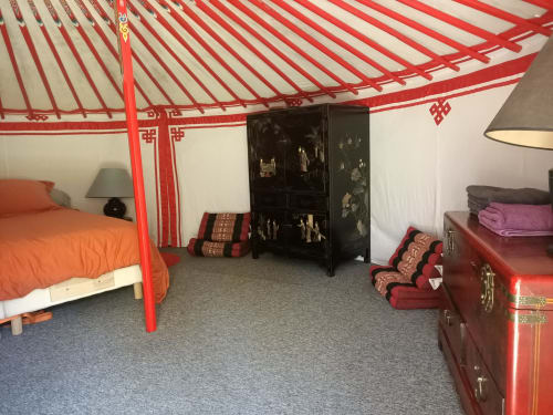 Chambre d'inspiration asiatique à Domaine De Maleval avec lit à baldaquin rouge, cabinet en laque noire et mobilier traditionnel