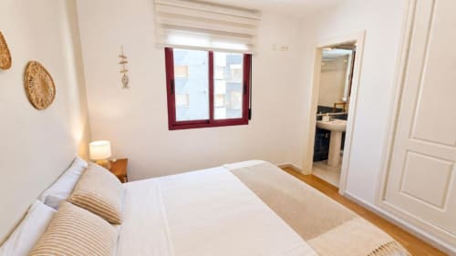 Dormitorio luminoso en Aloha Apartment, Calpe con vistas al mar, suelos de madera y equipamientos modernos
