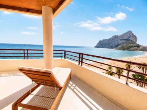 Vista desde el balcón de Aloha Calpe: tumbona con vistas a la playa de arena, el mar y la formación rocosa del Peñal d'Ifach en Calpe, España