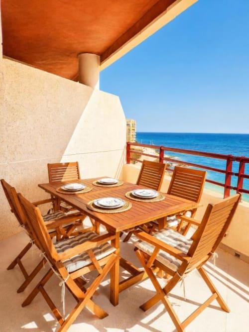 Comedor en terraza frente al mar en Aloha Calpe con muebles de madera con vistas al Mediterráneo