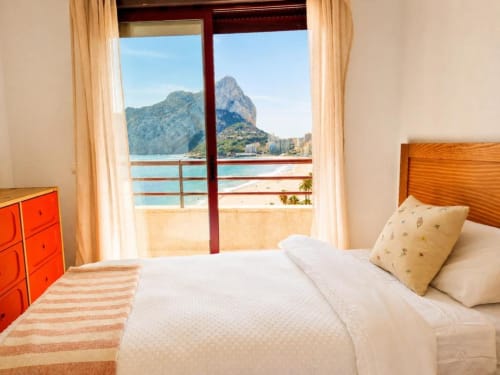 Dormitorio de apartamento dúplex en Calpe con balcón con vistas al mar, Peñón de Ifach y playa