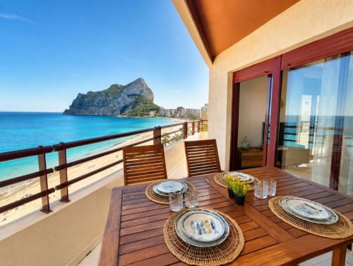 Terraza de dúplex Aloha Calpe con mesa de comedor con vistas a la bahía turquesa de Calpe y la formación rocosa del Peñyal d'Ifach