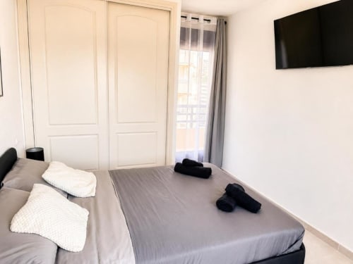 Dormitorio moderno en Aloha Calpe Duplex II con camas gemelas, TV, armario y balcón con vista al mar