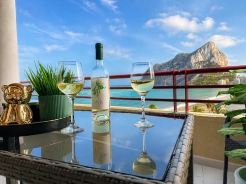 Copas de vino blanco en la terraza de Aloha Calpe con vistas al Peñal d'Ifach y el mar Mediterráneo, Calpe España