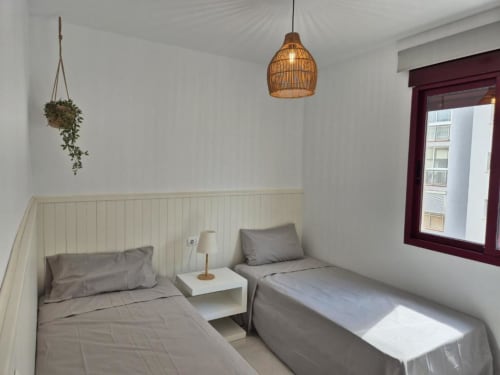 Dormitorio doble en el Apartamento Salinas de Aloha Calpe, Calpe con vistas al mar, iluminación colgante y mobiliario moderno