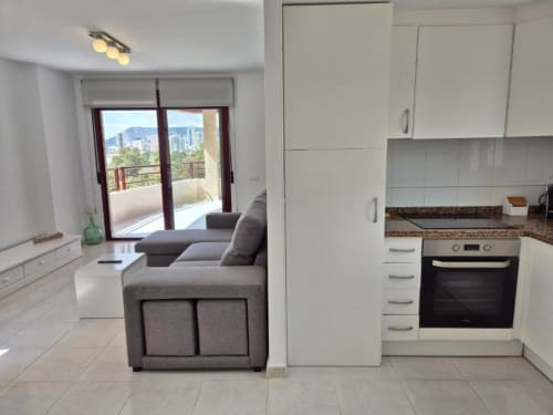 Cocina y salón modernos en Apartamento Salinas, Aloha Calpe, con vistas al mar y acceso a terraza