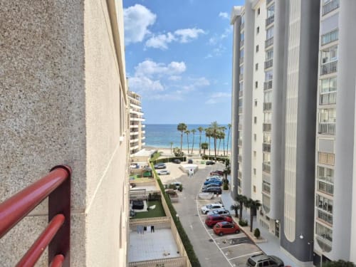 Vista desde el balcón del Apartamento Salinas en Aloha Calpe: Mar Mediterráneo, palmeras, playa y pueblo costero de Calpe