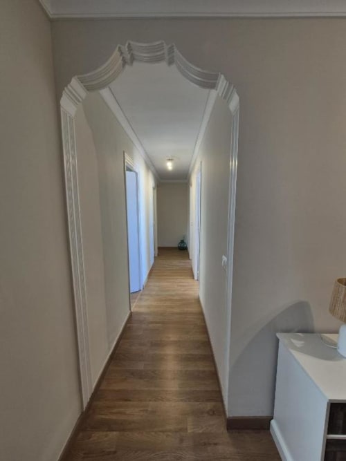 Largo pasillo con paredes blancas y suelo de madera en apartamento de Pueblo Antiguo de Aloha Calpe, Calpe