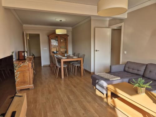 Apartamento en el Casco Antiguo de Calpe con sala de estar, mesa de comedor, sofá gris, muebles de madera y comodidades modernas