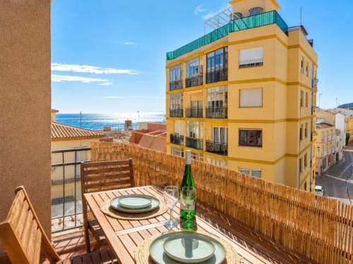 Terraza del apartamento Aloha Calpe en el casco antiguo con vistas al mar, zona de comedor y arquitectura de edificio amarillo
