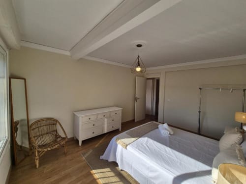 Amplio dormitorio en Aloha Calpe Old Town Apartment, Calpe, con vistas al mar, suelos de madera y mobiliario moderno