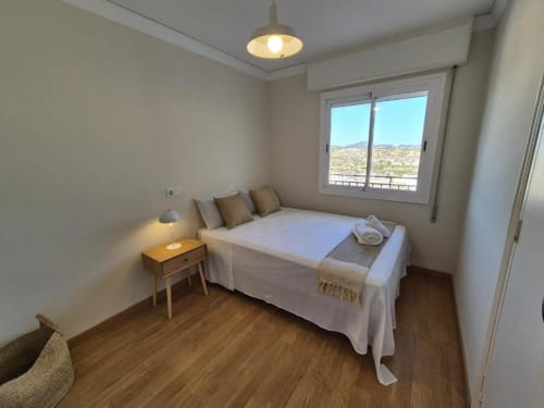 Dormitorio luminoso con vistas al mar en Aloha Calpe Old Town, Calpe con cama, lámpara de noche y vistas a la montaña