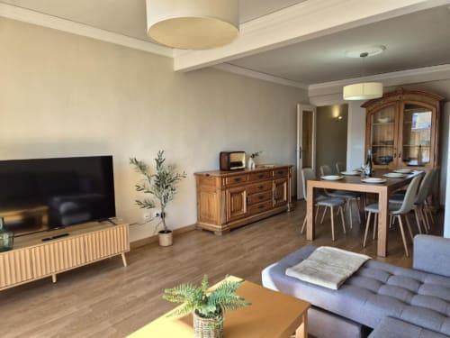 Apartamento moderno en el Casco Antiguo de Calpe con sala de estar, mesa de comedor, muebles de madera y vistas al mar desde el balcón