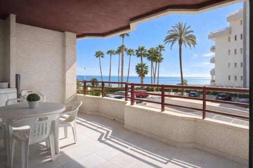 Balcón del apartamento Sea Palm con vistas al mar, palmeras y comedor al aire libre en el hotel Aloha Calpe de Calpe, España