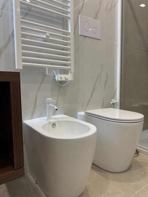 Bagno moderno con bidet e WC presso Maison ì Room a Reggio Calabria, caratterizzato da muri in marmo e scaldasalviette