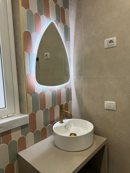 Bagno moderno con lavabo rotondo bianco, rubinetto in ottone e piastrelle backsplash pastel illuminate con motivo di foglie