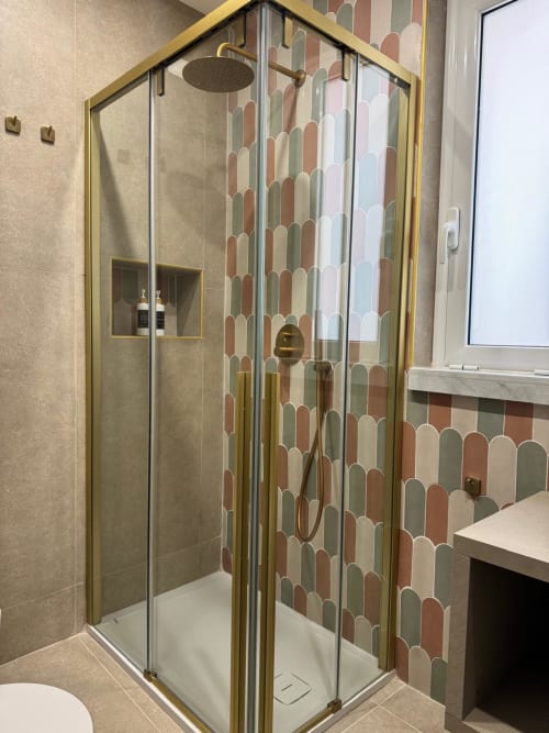 Moderno box doccia con telaio in ottone e piastrelle con motivi colorati nel bagno dell'hotel Maison ì Room, Reggio Calabria