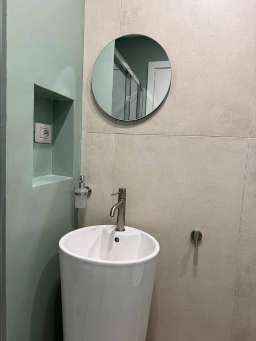 Lavandino moderno con specchio rotondo e nicchia piastrellata verde nell'appartamento Maison ì Room, Reggio Calabria