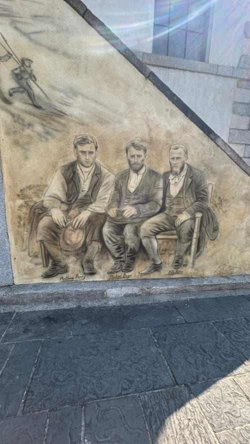 Mural at Madeline's Accommodation in Wicklow showing three historical figures seated together