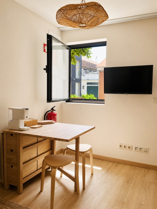 Patio Studio na Terra Clara em Esposende com escrivaninha de madeira, cadeiras, TV e janela com vista para o pátio