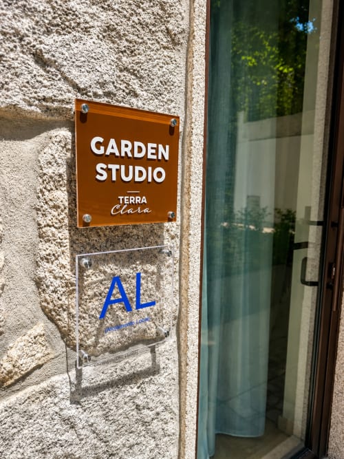 Placa de entrada do Garden Studio em Terra Clara, Esposende, com painel decorativo na parede