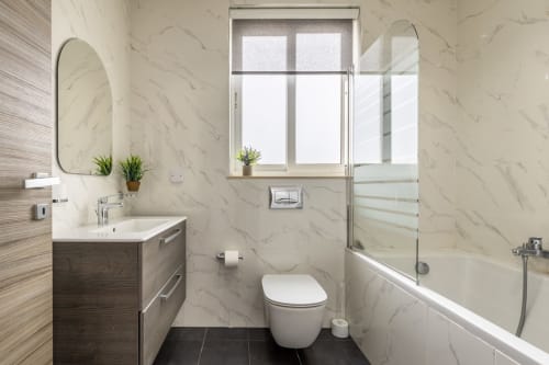 Bagno in marmo moderno nella Penthouse di lusso di Calm Holiday Homes, Ta-Xbiex con doccia aperta, lavabo e vista finestra