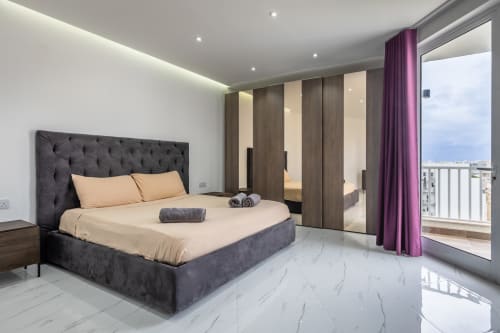 Lussuosa camera da letto con vista sulla città a Marsa, arredamento moderno, pavimenti in marmo e accesso alla terrazza