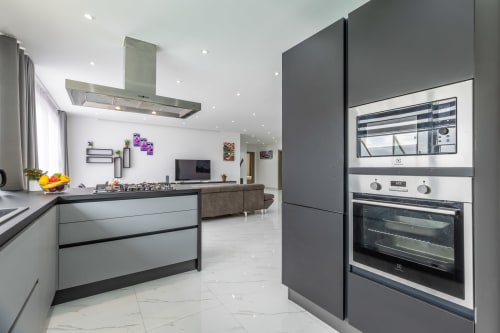 Cucina moderna di lusso nel penthouse di Ta-Xbiex, Marsa con elettrodomestici in acciaio inossidabile, isola centrale e zona living open-plan