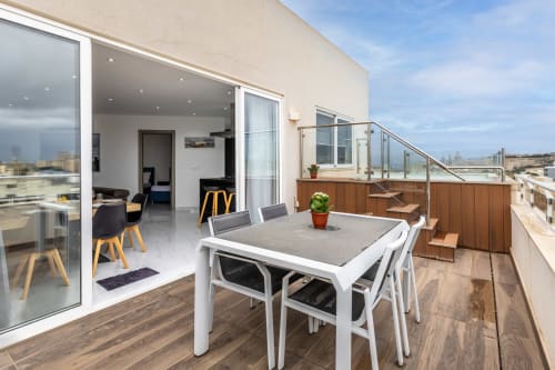 Terrazza di lusso a Ta-Xbiex, Malta con tavolo da pranzo, balaustre in vetro e vista sulla città