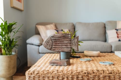 Coastal living room with wooden fish decor, potted plants, and gray sofa at Arestas e Planetas in Cascais