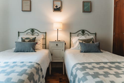 Twin beds with teal accents in Cascais Garden House bedroom, modern decor with garden view