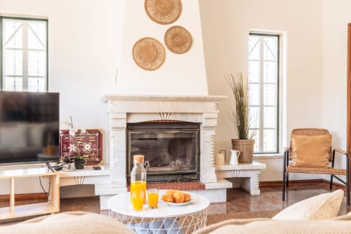 Sala moderna com lareira, decoração em trama na parede e assentos confortáveis na villa Arestas e Planetas em Amora, Portugal