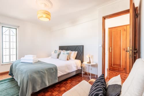 Quarto espaçoso na villa Arestas e Planetas, Amora, com cama queen, portas de madeira e vista para o jardim