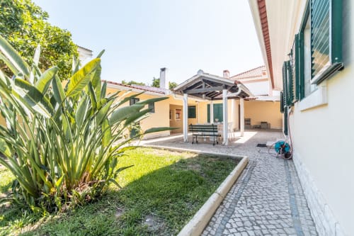 Jardim do pátio da villa Arestas e Planetas em Amora com terraço, assentos e vegetação exuberante