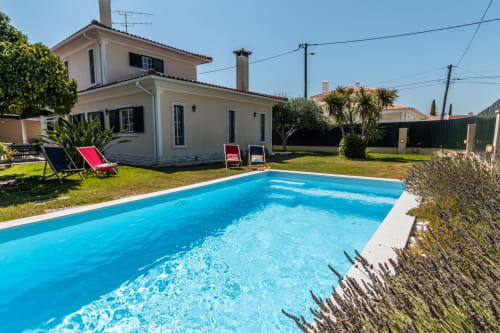 Vila com piscina privada em Amora, PT. Piscina cristalina, espreguiçadeiras e casa branca de dois andares rodeada por