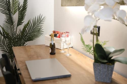 Moderna scrivania di hotel presso Roma Imperial Suites con laptop, calici di vino e piante in vaso a Roma