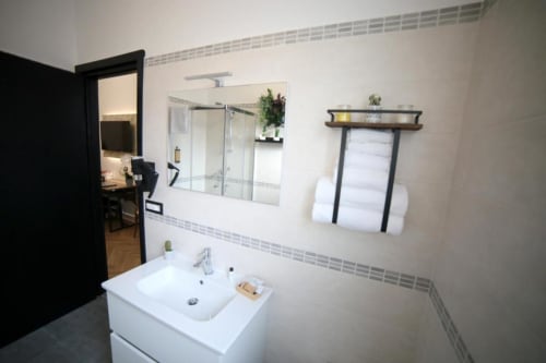 Bagno moderno nella Stanza Doppia Superior Romolo presso Roma Imperial Suites con lavabo bianco, specchio e servizi