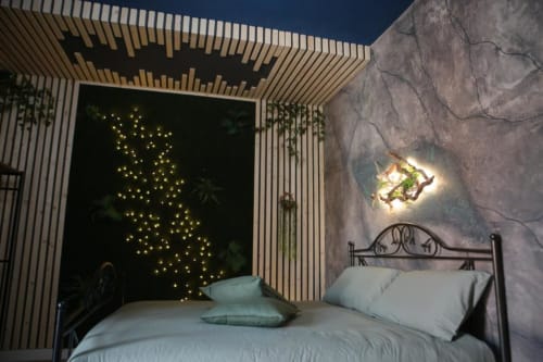 Camera matrimoniale deluxe presso Roma Imperial Suites con letto in metallo, opera d'arte murale con stelle illuminate e vista sulla città.