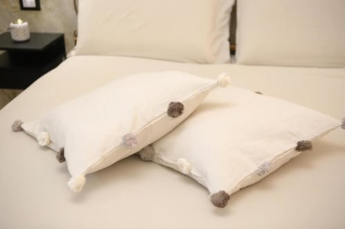 Cuscini decorativi color crema con dettagli pompon grigio e bianco sulla camera Superior Double Room delle Roma Imperial Suites