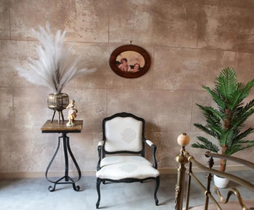 Elegante zona salotto nella suite Marco Aurelio di Roma Imperial Suites con poltrona nera classica e piante decorative