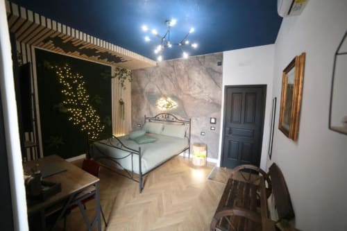 Suite Deluxe Numa Pompilio presso Roma Imperial Suites con letto in metallo, parete in marmo, pannello stellato, pavimento in parquet e