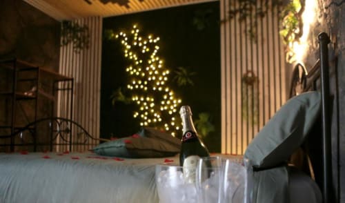 Romantica terrazza di Roma Imperial Suites con champagne, bicchieri e veduta della città illuminata a Roma