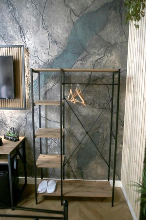 Appendiabiti in stile industriale con ripiani in legno e attaccapanni nella suite deluxe di Roma Imperial Suites