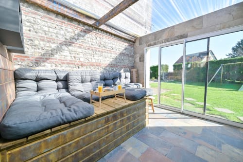 Lounge der Villa Ziane mit Palettenmöbeln, Oberlicht und Gartenblick in der Nähe von Étretat